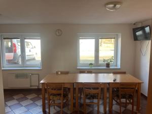 a dining room with a wooden table and two windows at Ubytování Sedmička in Dolní Rožínka +20 photos