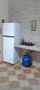 a kitchen with a white refrigerator and a stove at Casa formosa in Porto Seguro