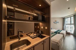 eine Küche mit einem Waschbecken und ein Bett in einem Zimmer in der Unterkunft Apec Mandala Ocean Retreat - Mui Ne in Mui Ne