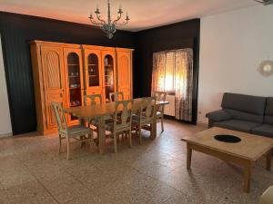 a dining room with a table and chairs and a couch at El Portachuelo in Toledo