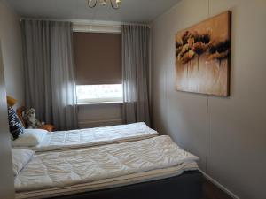 a bed in a bedroom with a painting on the wall at Pieksämäellä saunallinen rivitalokaksio in Pieksamaki