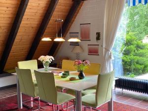 a dining room with a white table and chairs at Ferienhaus im Birkenweg in Worpswede