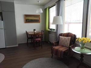 a living room with a table and a chair at Pieksämäellä saunallinen rivitalokaksio in Pieksamaki +5 photos