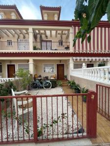 a house with a red and white fence at Oasis en la playa con piscina in San Pedro del Pinatar