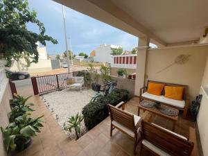 a patio with a couch and chairs on a balcony at Oasis en la playa con piscina in San Pedro del Pinatar