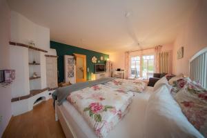 a bedroom with a large bed with a floral bedspread at Aurora#1 mit großem Garten, Sauna und Kamin in Wiesmoor