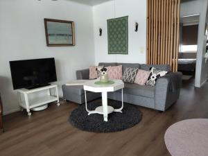 a living room with a couch and a table at Pieksämäellä saunallinen rivitalokaksio in Pieksamaki