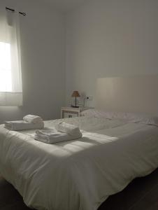 a white bed with two towels on top of it at La Olmeda del Maripinar in Cieza +12 photos