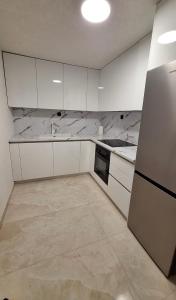 a kitchen with white cabinets and a refrigerator at Villa M in Neum