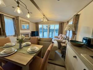 a kitchen and living room with a table and a couch at Sunset View, Dog Friendly, Free Hoburne Passes in South Cerney