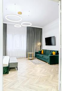 salon z zieloną kanapą i stołem w obiekcie High Ceilings Apartments Bucharest GARDEN - Parking w Bukareszcie