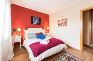 a bedroom with a white bed with red walls at The Escorial House in Escorial +58 photos