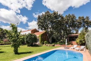 a backyard with a swimming pool and a house at The Escorial House in Escorial