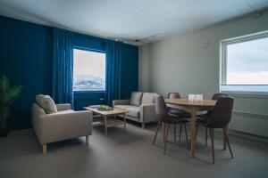 a living room with a table and chairs at Sommarøy Apartment 2nd floor in Sommarøy