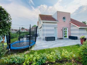 a house with a backyard with a trampoline at familienfreundliches Ferienhaus mit Ruderboot, Sauna und Kamin sowie E-Ladestation in Makkum