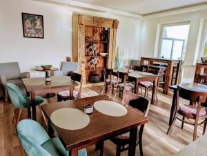 un ristorante con tavoli e sedie in una stanza di Hotel Tausendschön a Südbrookmerland