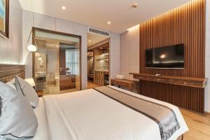 ein Schlafzimmer mit einem Bett und einem Flachbildfernseher in der Unterkunft Apec Mandala Ocean Retreat - Mui Ne in Mui Ne