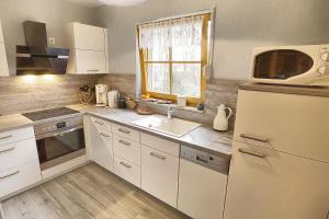 a kitchen with a white refrigerator and a sink at Schwalbenweg in Zingst