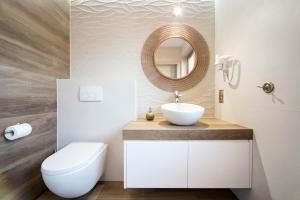 a bathroom with a sink and a toilet and a mirror at Apartamenty w centrum Krakowa nad Wisłą in Kraków