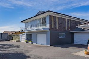 a house with a balcony and a driveway at GeoHaven Rotorua Earths Embrace in Rotorua