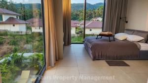 ein Schlafzimmer mit einem Bett und einem großen Fenster in der Unterkunft Coconut Lane's Secret Villa, Secluded, Spacious, Hi-tech, 2-floor, Priv Garden & Saltwater Pool in Ko Phangan
