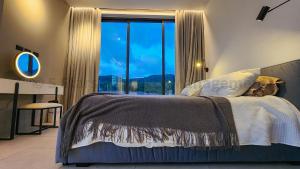 ein Schlafzimmer mit einem Bett mit einem großen Fenster in der Unterkunft Coconut Lane's Secret Villa, Secluded, Spacious, Hi-tech, 2-floor, Priv Garden & Saltwater Pool in Ko Phangan + 16 Fotos