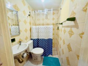 a bathroom with a toilet and a sink at Guest House Rosa do Mar in Olinda