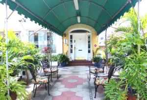 a porch with chairs and plants in front of a building at The Inn On Third in St Petersburg
