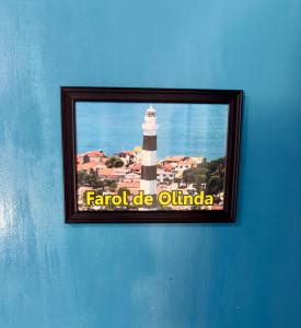 a picture of a lighthouse on a blue wall at Guest House Rosa do Mar in Olinda