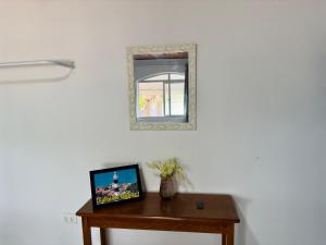 a mirror on a wall next to a wooden table at Guest House Rosa do Mar in Olinda