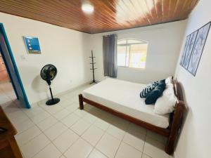 a bedroom with a bed and a fan in it at Guest House Rosa do Mar in Olinda
