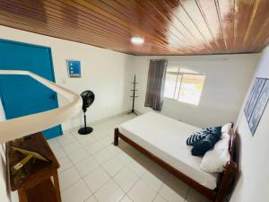 a bedroom with a bed with a wooden ceiling at Guest House Rosa do Mar in Olinda