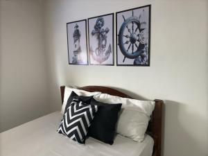 a bed with four pictures on the wall above it at Guest House Rosa do Mar in Olinda
