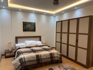 a bedroom with a bed and a large closet at Rehab Modern Apartment in New cairo