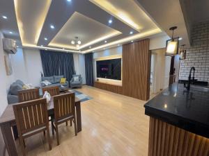 a living room with a kitchen and a living room with a table at Rehab Modern Apartment in New cairo