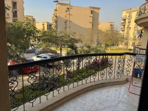 a balcony with a wrought iron fence and a parking lot at Rehab Modern Apartment in New cairo