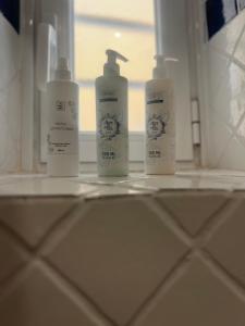 three bottles ofodorizers sitting on a shelf in a bathroom at L'Aurora Casa Vacanze in Anzio +15 photos