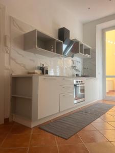 a kitchen with white cabinets and a stove at L'Aurora Casa Vacanze in Anzio