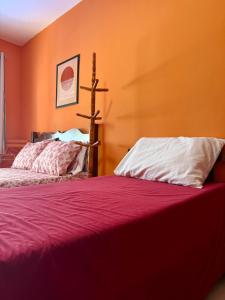 two beds in a room with orange walls at Guest House Rosa do Mar in Olinda