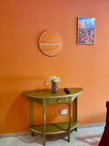 a table with a vase of flowers on a wall at Guest House Rosa do Mar in Olinda