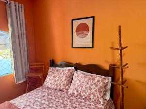 a bedroom with a bed with orange walls at Guest House Rosa do Mar in Olinda