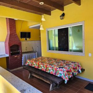 a bed in a room with a yellow wall at FLATS Beira Mar Prainha Barra de Sao Joao - Rio das Ostras in Barra de São João