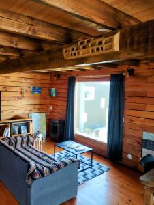 a living room with a couch and a large window at Pizarra Escondida in El Chalten