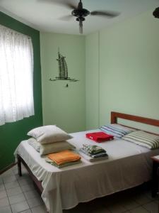 1 dormitorio con 1 cama con pared verde en Santoro Gali 210, en Florianópolis