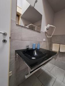 een badkamer met een zwarte wastafel en een spiegel bij Bedroom la stazione in Palermo +47 foto's