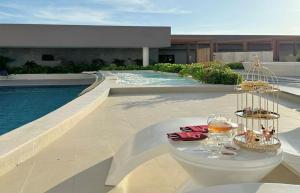 ein Tisch mit Gläsern Wein darauf neben einem Pool in der Unterkunft Apec Mandala Ocean Retreat - Mui Ne in Mui Ne