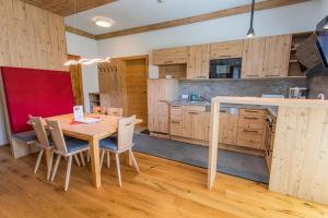 a kitchen with wooden cabinets and a wooden table and chairs at Bergidyll 4 by Alpenidyll Apartments in Ramsau am Dachstein