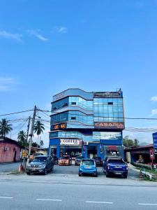 a parking lot with cars parked in front of a building at Hotel Casaria in Paka