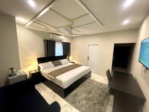 una camera da letto con un letto e una TV a schermo piatto di Whispering Hearts Guest House a Botianaw