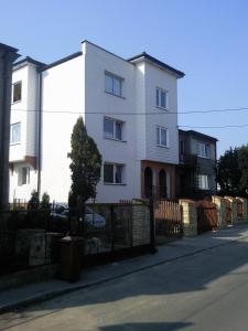 a white building on the side of a street at Noclegi Przy Szpitalu in Toruń